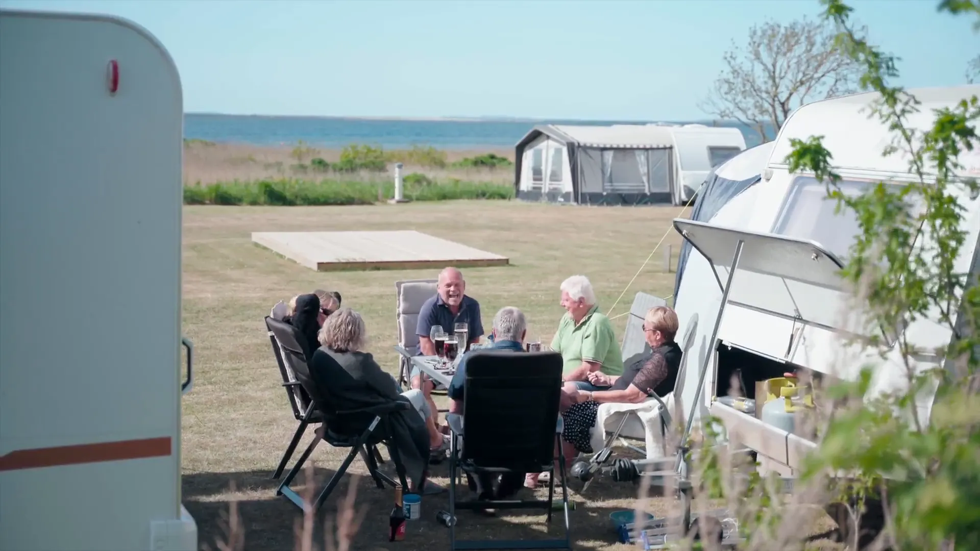 Caravans en gasten op het gras met uitzicht over de Limfjord