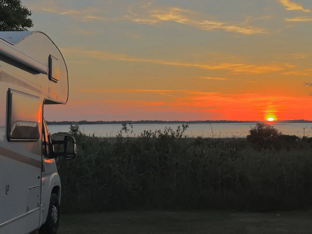 Motorhome on a panorama pitch with the sun setting over the Limfjord