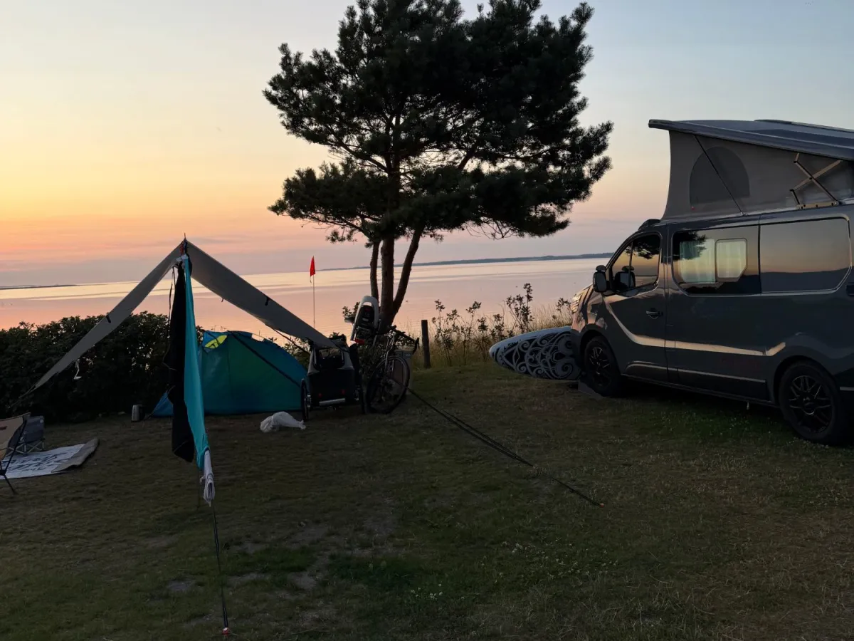 Tent, tarp and pop-top campervan at sunset on a panorama pitch