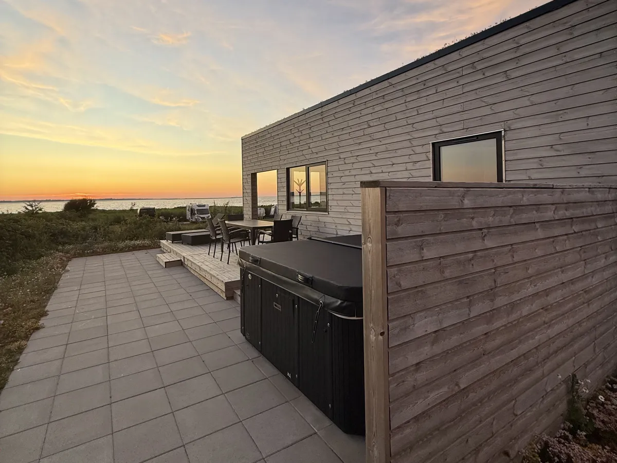 Terras met spa bij het Premium Limfjord-huisje in het avondlicht