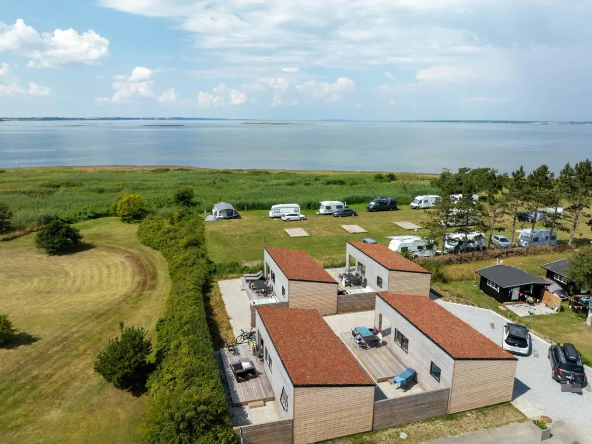 De Premium Limfjord-huisjes met groen dak van bovenaf met de Limfjord