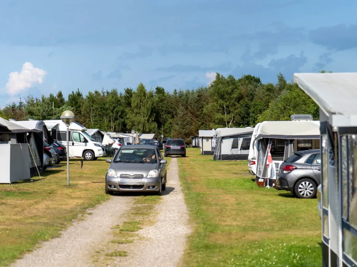 Grusvej mellem sæsonpladserne med campingvogne, store fortelte og biler