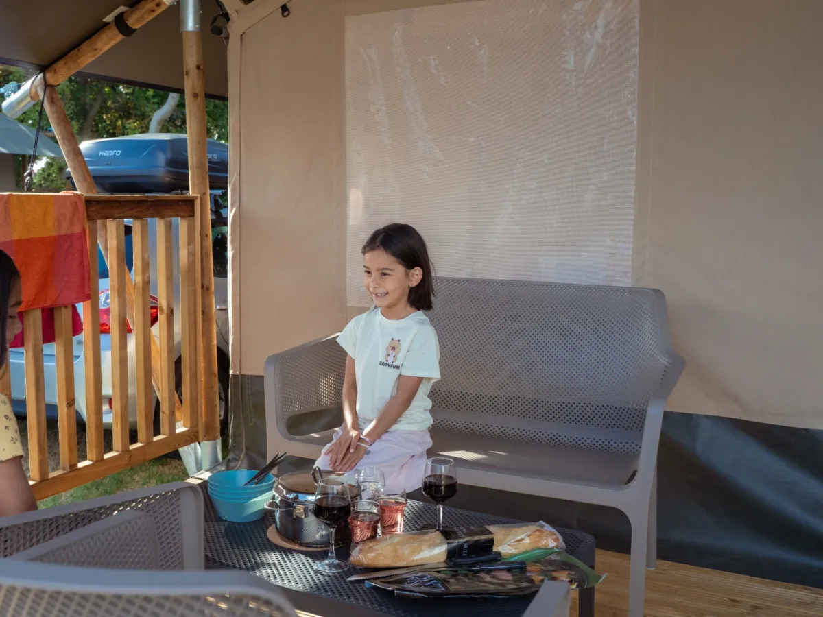 Vrolijke kinderen eten op het terras voor de safaritent