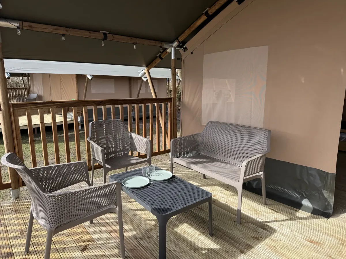 Terrasse med havemøbler foran safariteltet