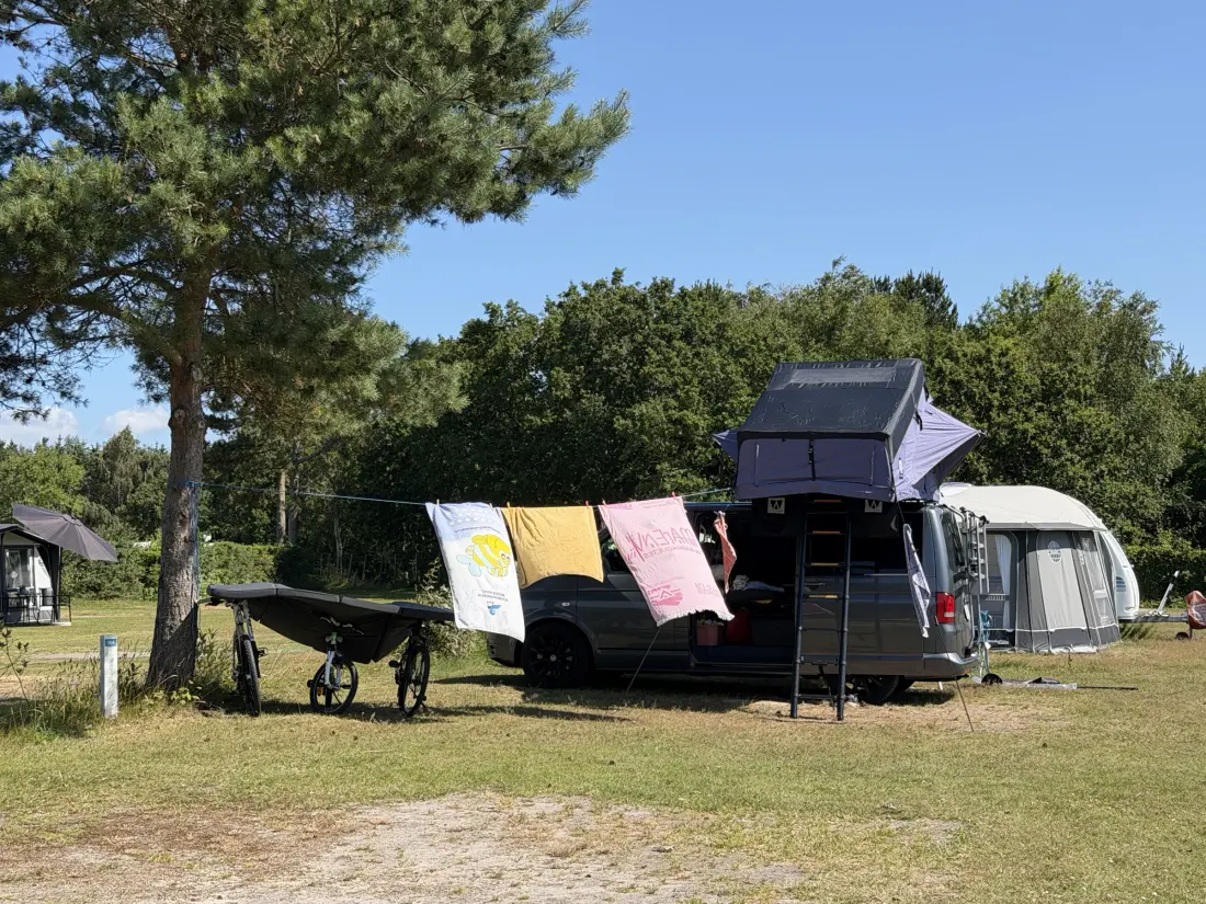 Campervan met daktent en waslijn op een standaardplaats