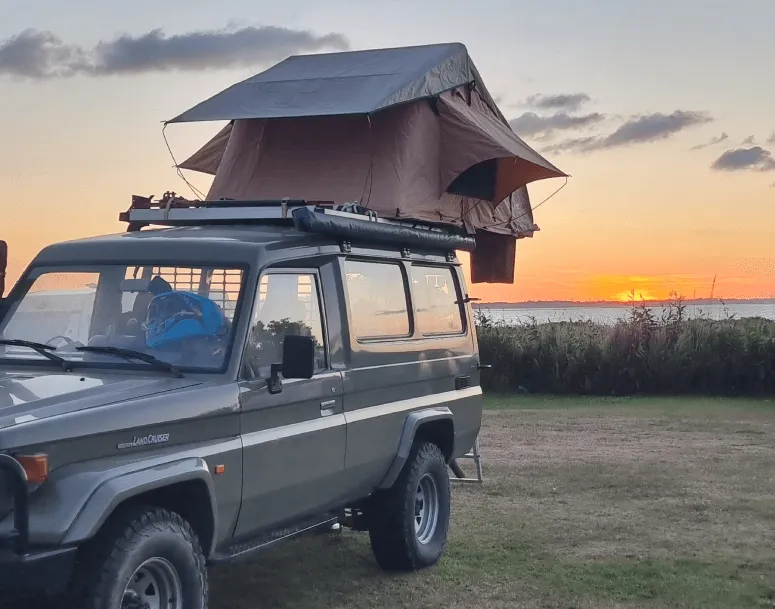 Daktent op een auto op de camping