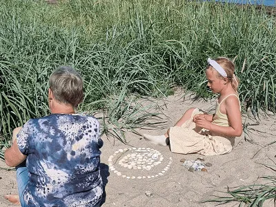 Oma en kleinkind spelen op het strand