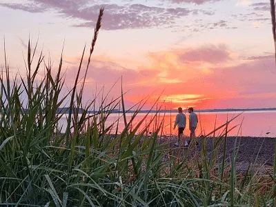 Stel wandelt bij zonsondergang op het strand