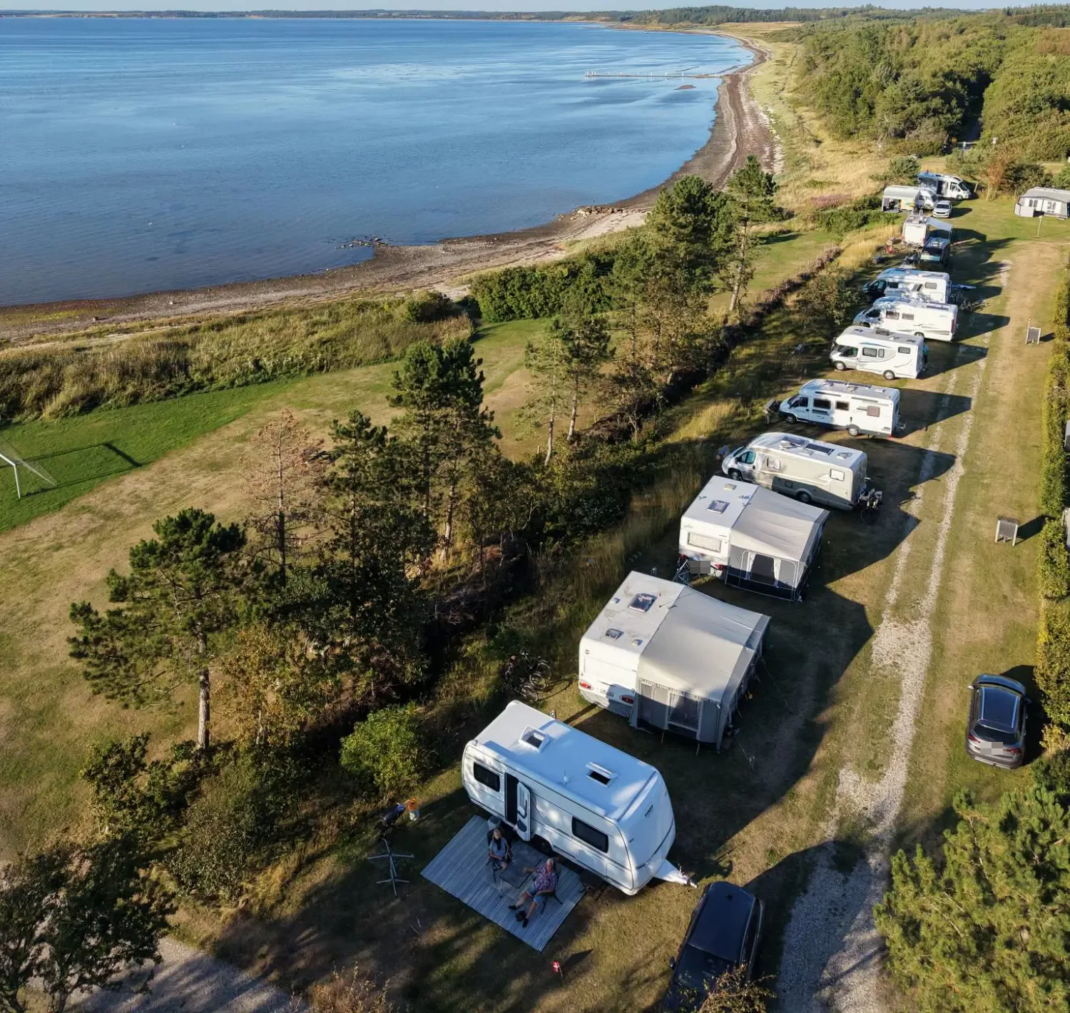Caravans and motorhomes on the front-row view pitches along the Limfjord coast, seen from above