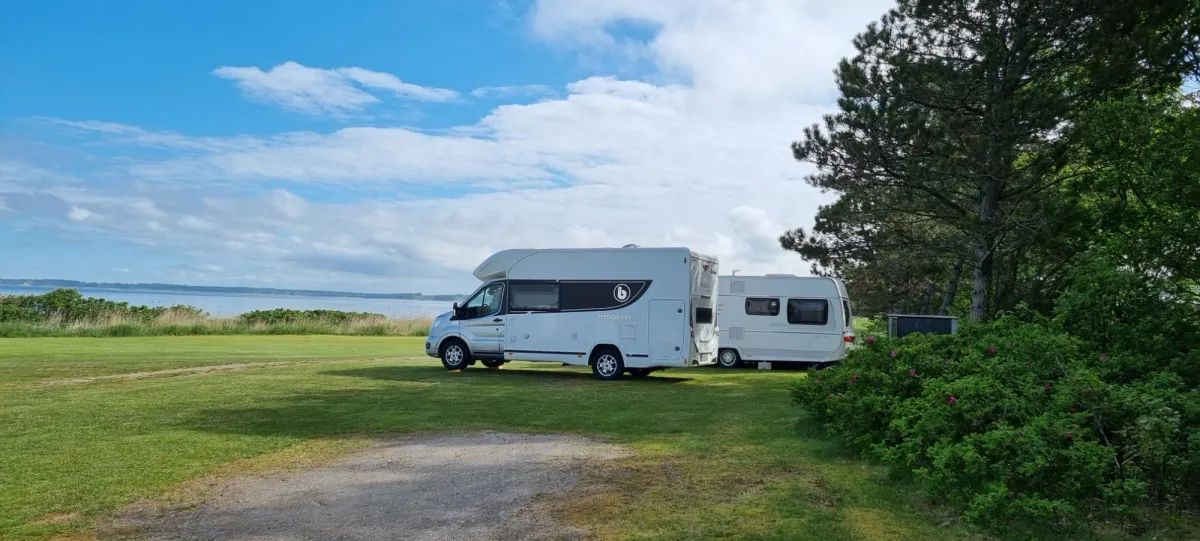 Motorhome and caravan on the grass with the Limfjord behind