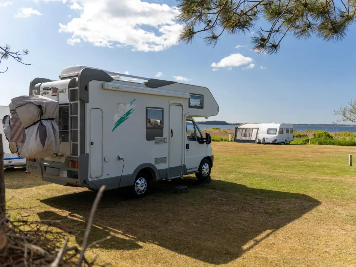 Camper op een uitzichtplaats met de Limfjord en een caravan met voortent erachter