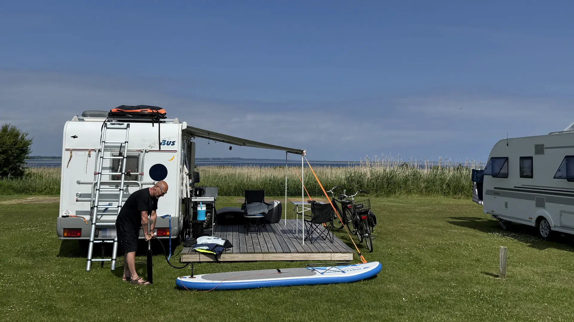 Motorhome on a view pitch with a wooden deck overlooking the Limfjord