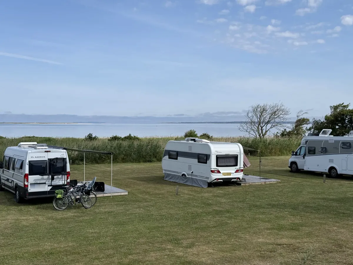 View pitches with decks and motorhomes with the Limfjord behind