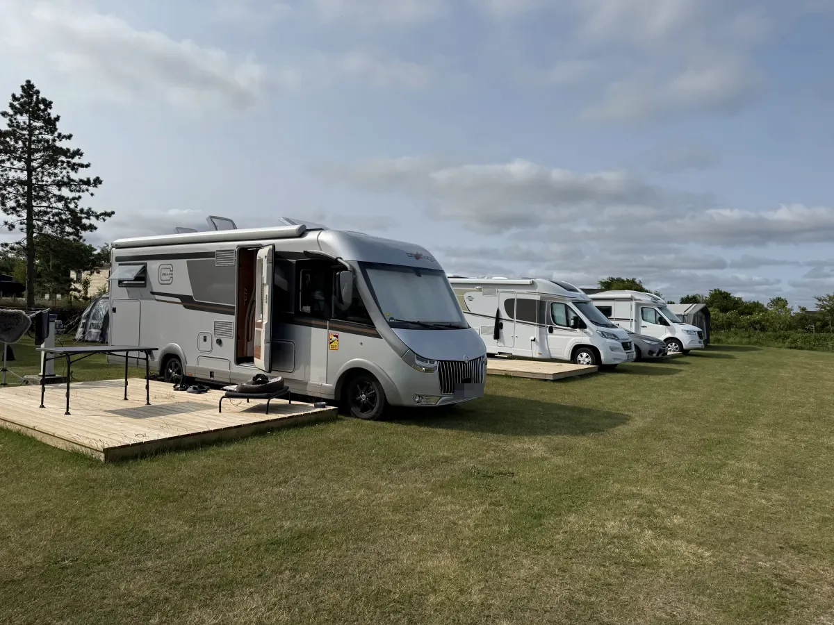 Motorhomes in a row on view pitches with wooden decks